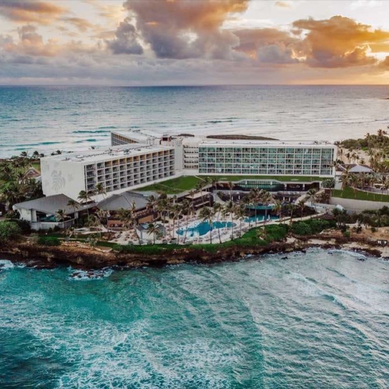 Aerial view of a North Shore Oahu resort at sunset, palm trees and coastline