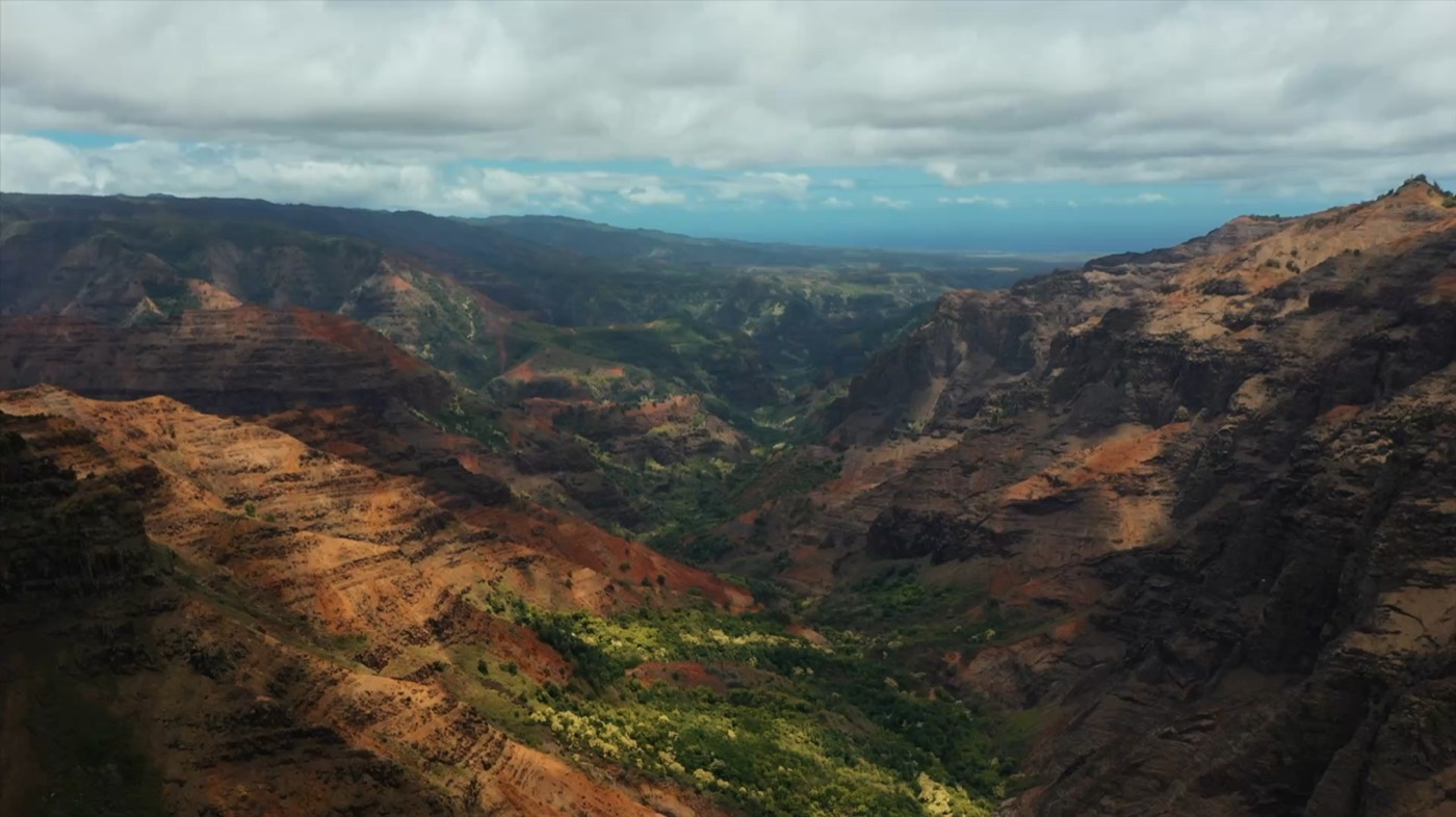 Waimea Canyon on Kauai, layered red and green canyon walls under a cloudy sky